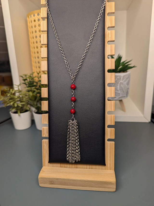 Collier long, sautoir, avec une chaine de couleur argent, des perles naturelles de turquoise rouge, et un pompon en chaine argentée. 