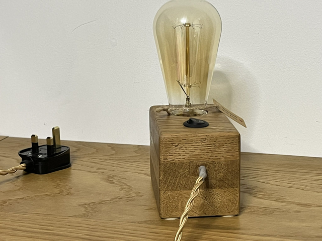 Rustic bedside lamp made of oak wood with a switch and an Edison bulb.