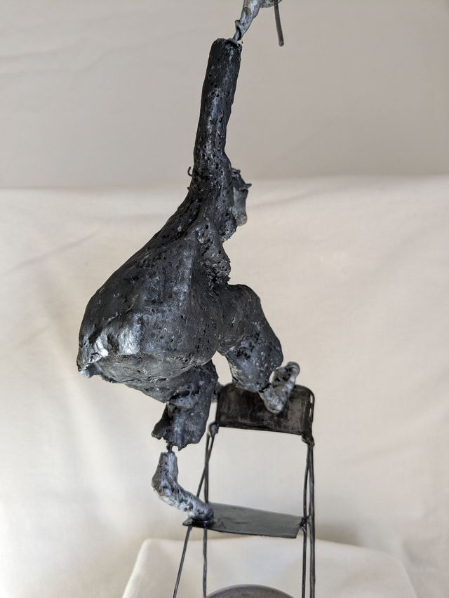 L'équilibriste sur une chaise, sculpture noire et argent