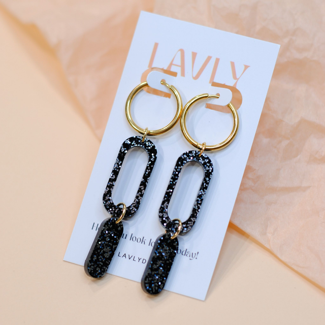 Välke-korvakorut, musta glitter, kullattu teräs