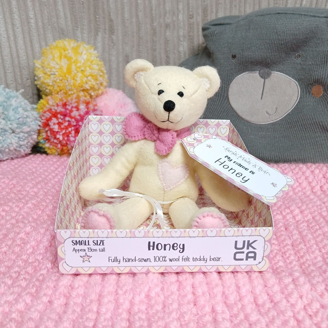 Honey. Small size, handmade teddy bear. UKCA. Tray base packaging. Standard Wool Felt. Pastel yellow. Cherry blossom pink. Blush. Baby Pink.