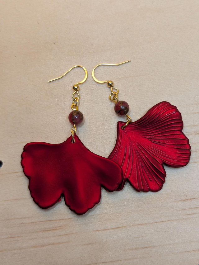 Boucles d'oreilles avec pendentifs en forme de feuilles de couleur rouge métallisé avec des perles de cloisonne rouge et marron.