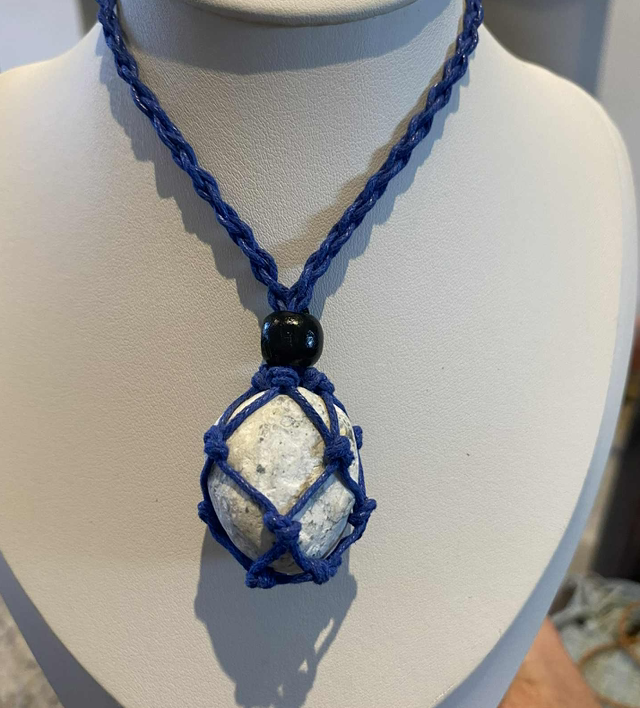 Adjustable necklace containing whitish pebble