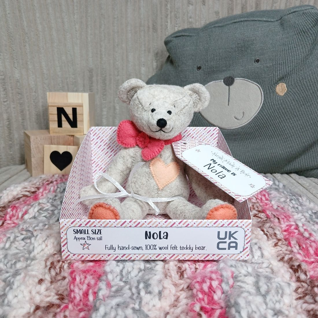Nola. Small size, handmade teddy bear. UKCA. Tray base packaging. Standard Wool Felt. Fluffy beige. Sorbet pink. Peach. Coral.