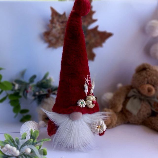 Tomte lutin de Noël au bonnet rouge et citrouilles dorées