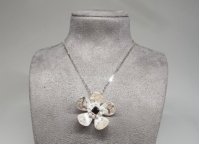 Bee print flower pendant with dark emerald cubic zirconia on silver necklace