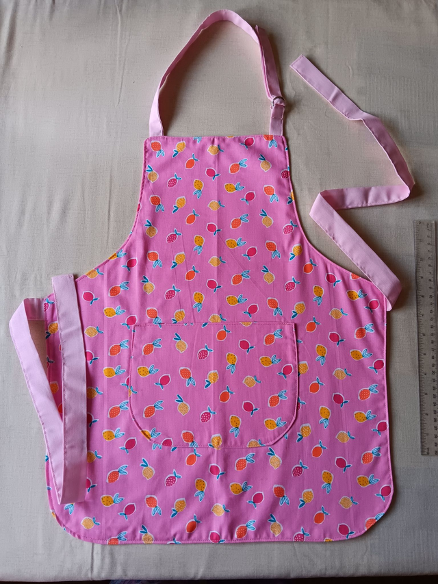 Childs Kitchen Play Apron Pink Fruit Patterned Cotton Fabric with Front pocket and Pink lining, waist ties and adjustable neck ties 