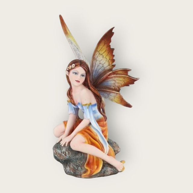 Fée élégante assise sur roche 