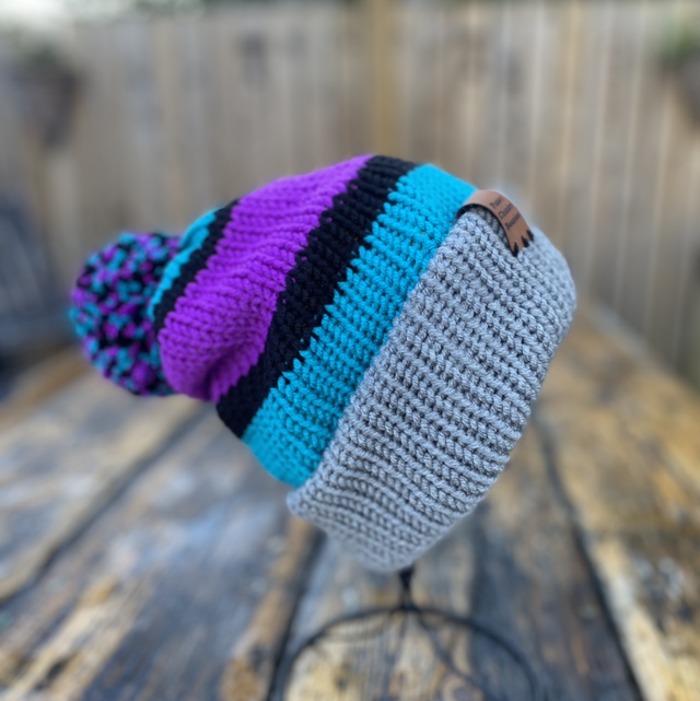 Adult beanie. 90’s saved by the bell colours! Blue, purple and black with a grey brim