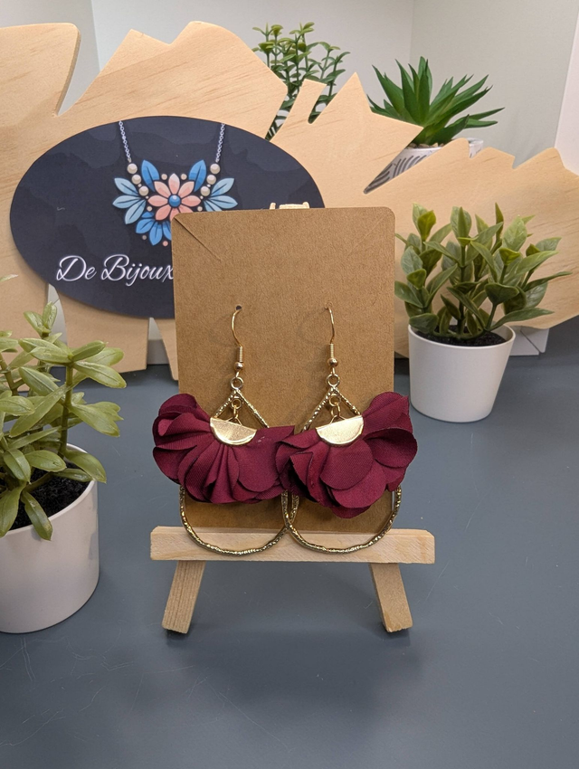 Boucles d'oreilles en forme de goutte doré avec pompon plat bordeaux et fermoir doré. 