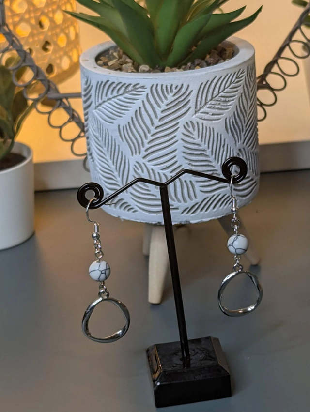 Boucles d'oreilles pendante avec des perles naturelles et un pendentif en couleur argent. Le fermoir est en argent 925.