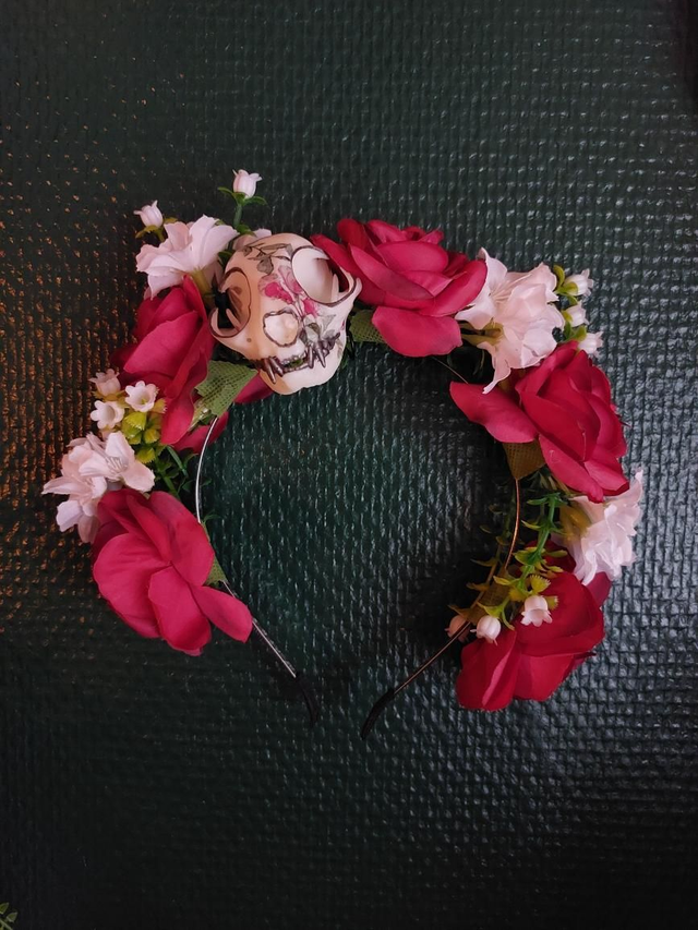 Couronne de fleurs rouges avec un crâne de chat en résine 
