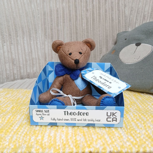 Theodore. Small size, handmade teddy bear. UKCA. Tray base packaging. Standard Wool Felt. Brown. Blue.