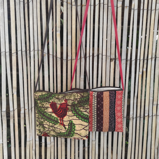 Pochette en tissu coton imprimé, doublée. Fine bandoulière, fermeture zipée.