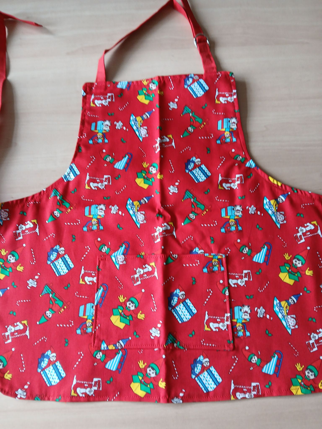 Childs Kitchen Play Apron Festive Patterned Cotton Fabric with Front pocket and Red lining, waist ties and adjustable neck ties