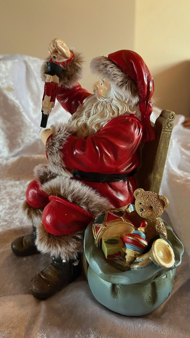 Weihnachtsmann auf Sessel – mit einem Sack mit Geschenken-liebevoll gestaltete Weihnachtsfigur