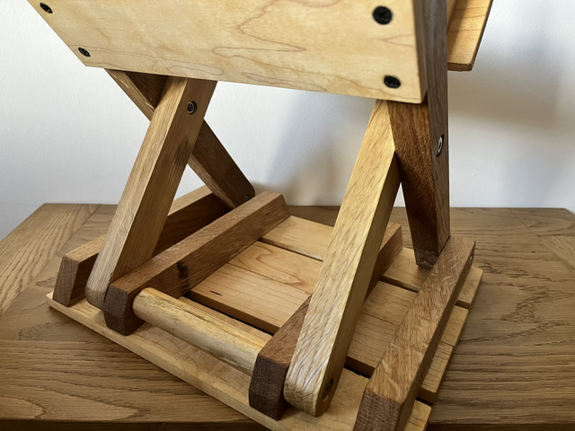 Wooden, folding camping stool made of oak and maple wood.