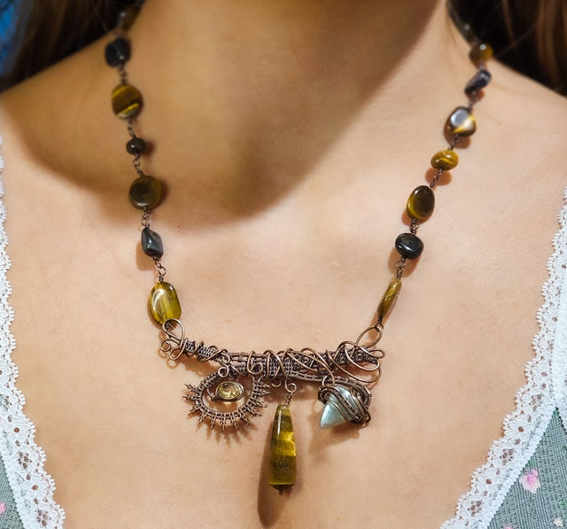 A freestyle wire woven  antiqued copper necklace with Tiger's Eye, Hawk's Eye, a faceted Citrine and a labradorite cabochon. 