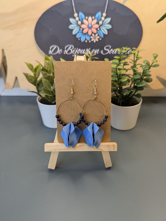 Petites boucle d'oreille créole en perles naturelles noire et des breloque en forme de pétales bleu. 