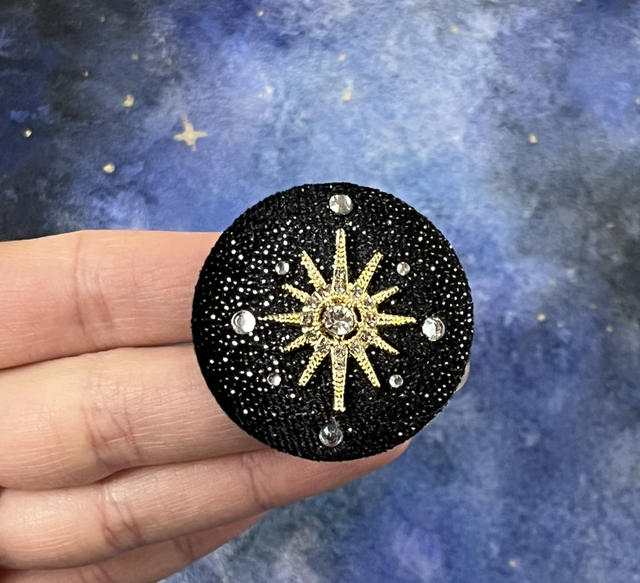 Broche noir pailletée avec étoile galactique