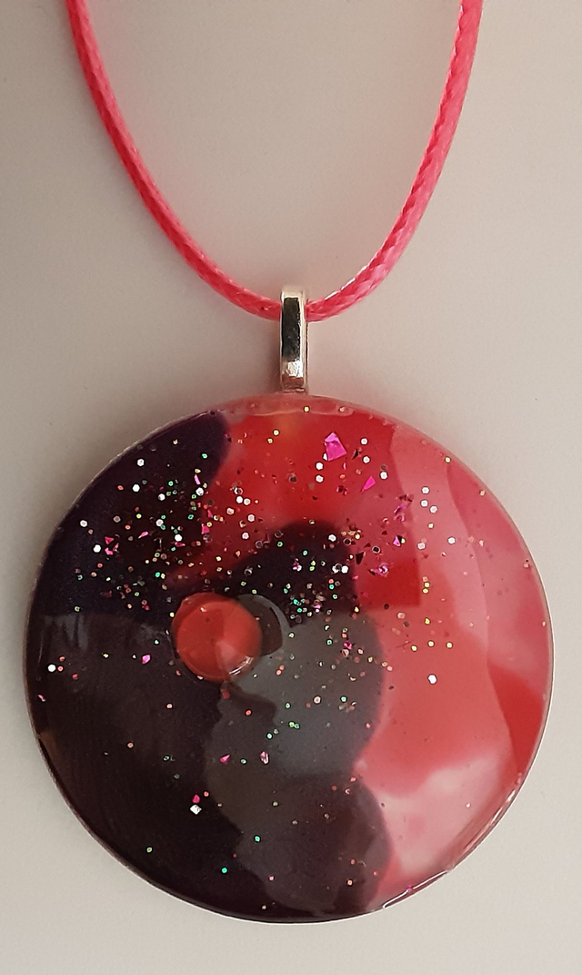 Pendentif rond collection Mouna Paillette couleur raisin et framboise parsemé de paillettes roses et cabochon rose
