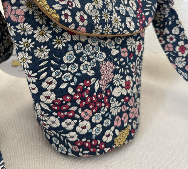 Schultertasche mit Blumen auf blauem Hintergrund