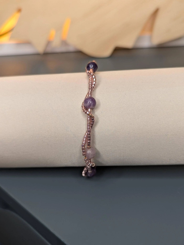 Bracelet torsadé violet foncé, avec des perles Miyuki en verre et des perles naturelles violettes sur fil de fer. le fermoir est de couleur or.