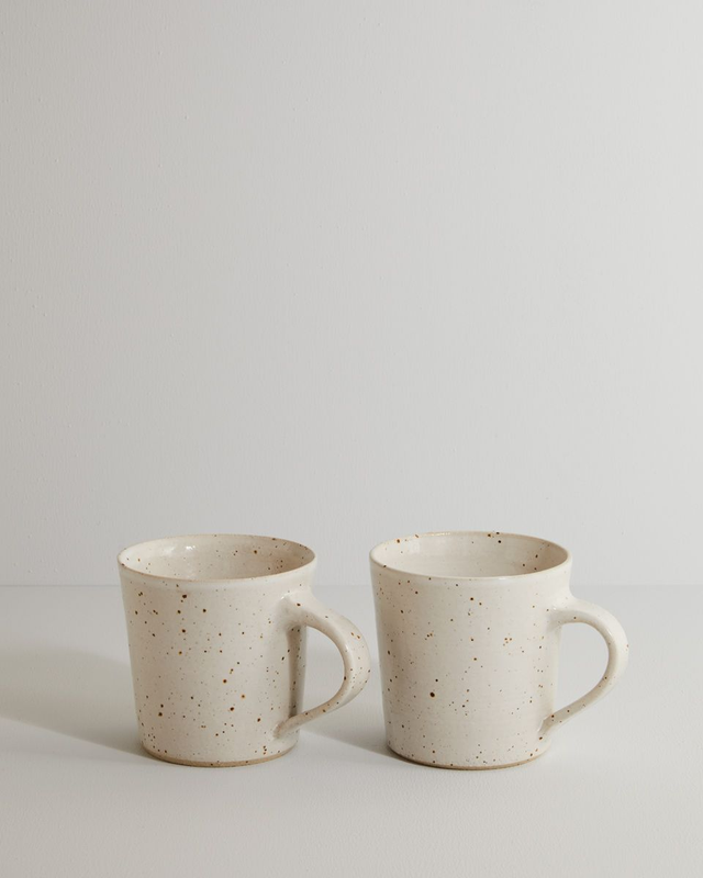 A pair of white speckle mugs