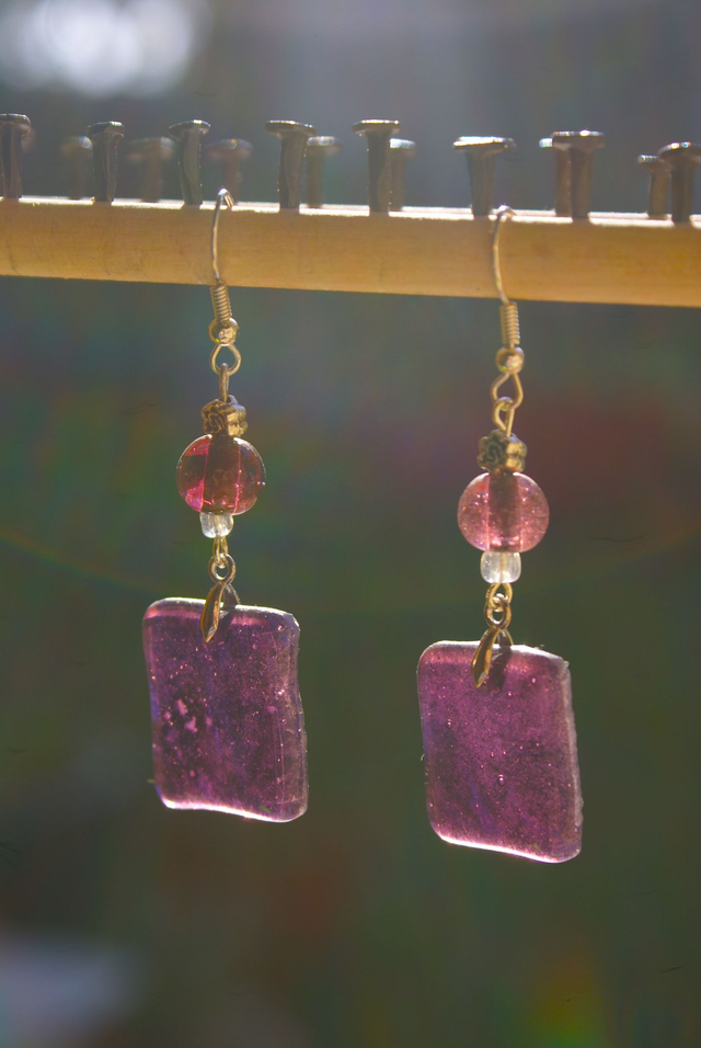 Boucles d&#039;oreilles en verre prune pâle transparent. 
