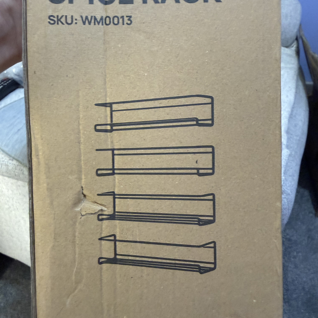 Solid metal spice rack in black with four shelves and individual bracket