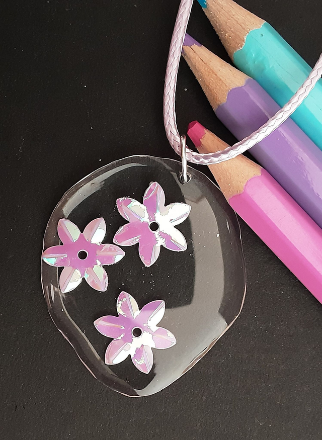 médaillon transparent et fleurs irisées mauves