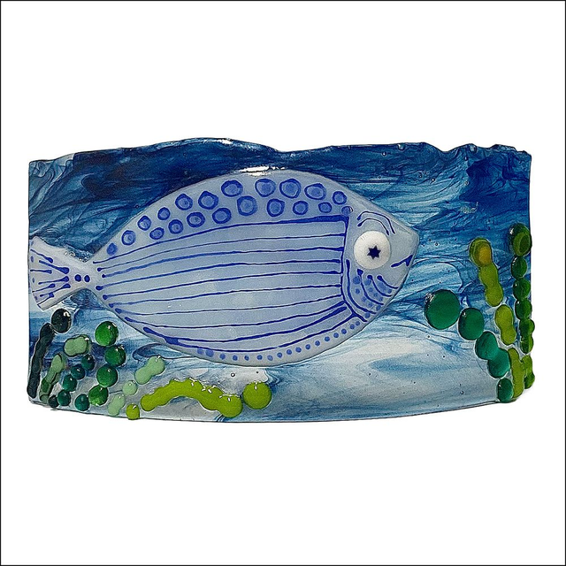 Curved glass ornament of a funky blue fish with seaweed 