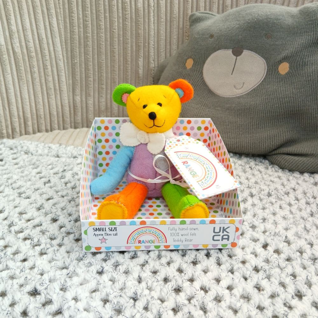 Rainbow. Small size, handmade teddy bear. UKCA. Tray base packaging. Standard Wool Felt. Yellow. Orange. Pink. Blue. Purple. Green. White.