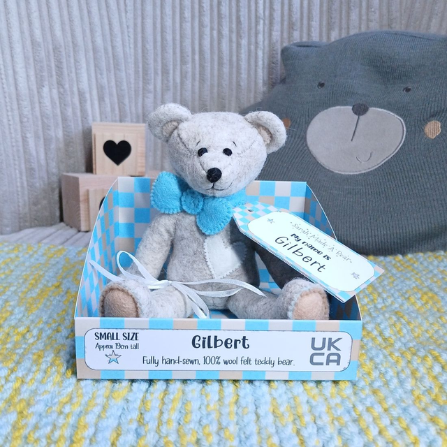 Gilbert. Small size, handmade teddy bear. UKCA. Tray base packaging. Standard Wool Felt. Beige. Caramel. White. Aqua blue.