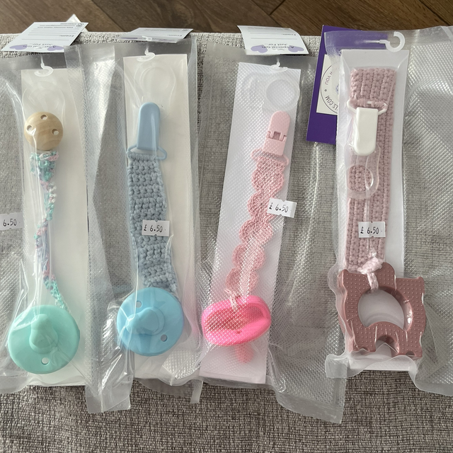 Dummy teething device with a crochet clip on strap