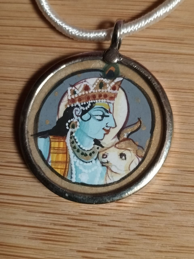 Pendentif avec cordon Krishna souriant avec Kamadhenu, la Vache sacrée