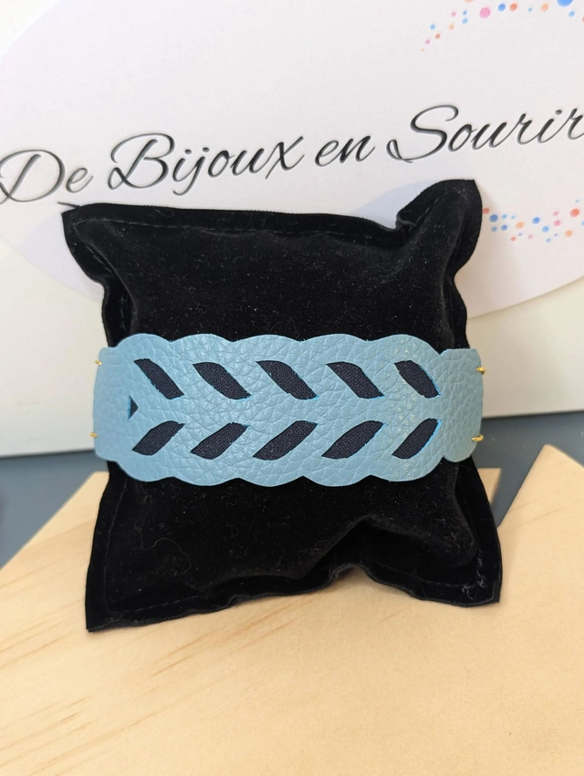 Bracelet manchette en cuir bleu, avec du tissus enduit bleu foncé (résistant), une chaine dorée. Le fermoir est de couleur doré.