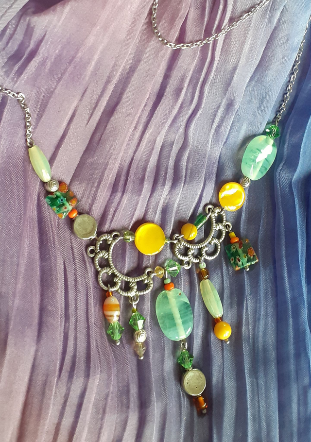 Collier forme plastron, breloques métalliques et perles diverses, ton jaune d'or, vert d'eau