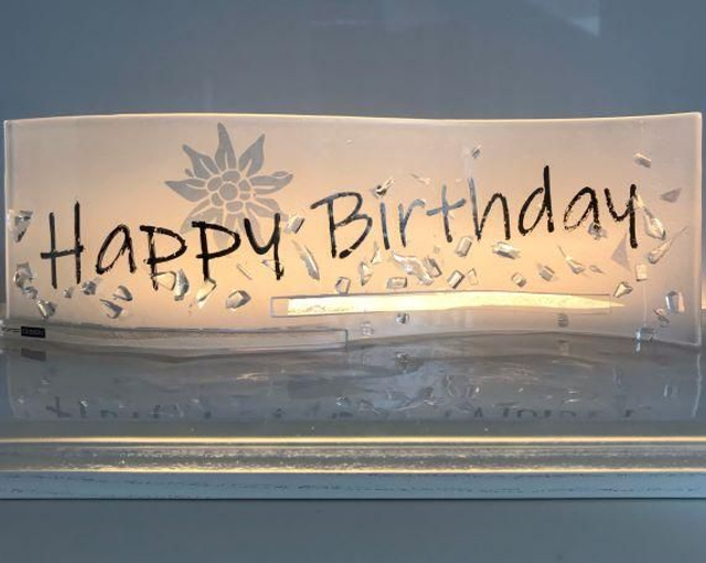 o13 Happy Birthday-Welle aus Glas mit versilbertem Schriftzug . 10 x 30 cm