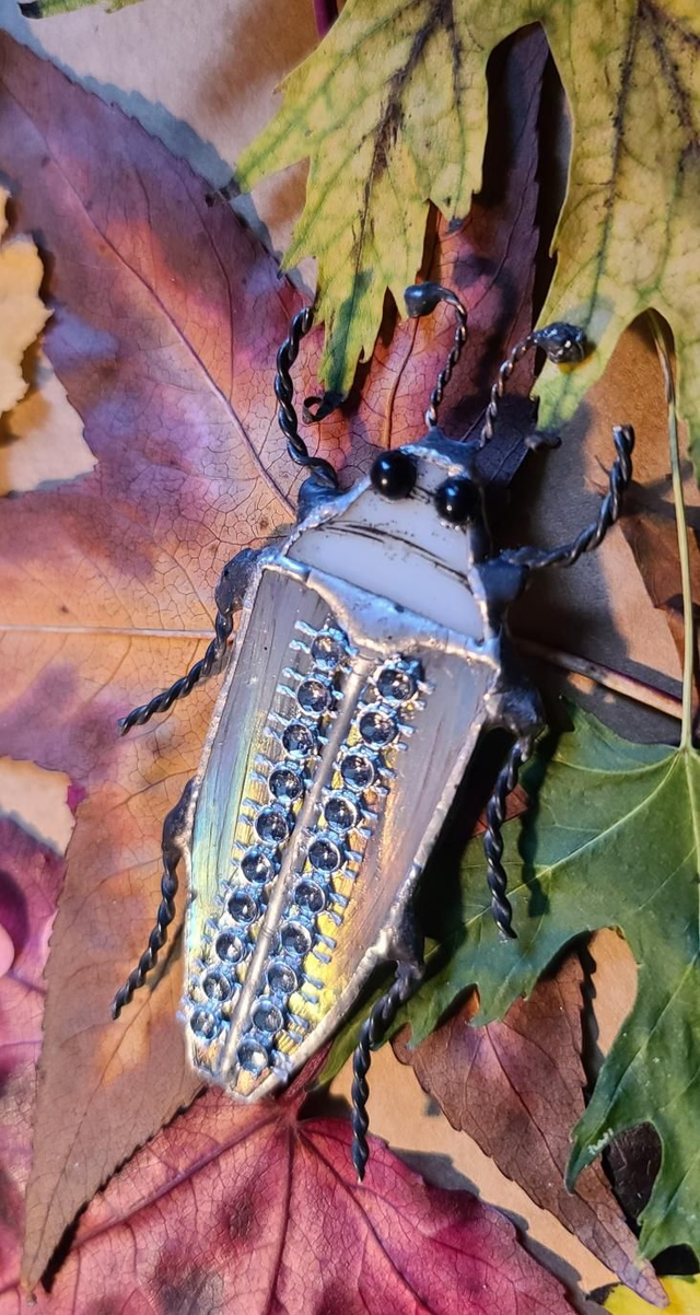 Scarabée en verre, au corps blanc iridescent et à la tête blanche, en Tiffany, monté en magnet. 