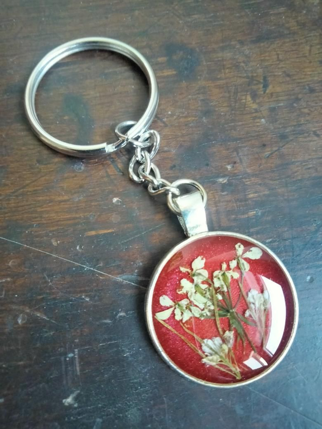 Porte clé forme ronde avec inclusion d'une fleur séchée de carotte sauvage 