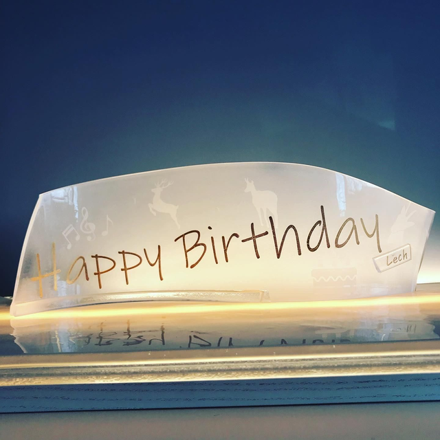 o13 Happy Birthday-Welle aus Glas mit vergoldetem Schriftzug . 12 x 30 cm