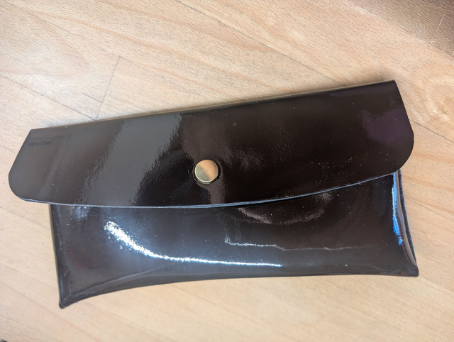 Pochette en cuir vernis.