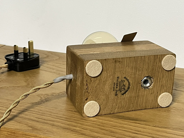 Rustic bedside lamp made of oak wood with a switch and an Edison bulb.