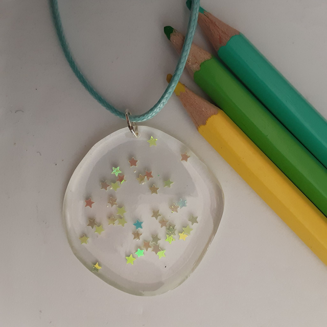 médaillon transparent et étoiles irisées vertes