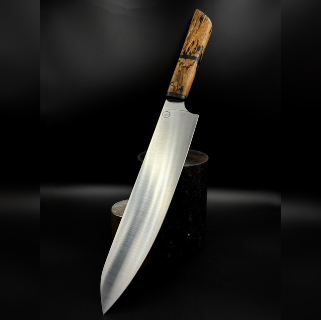 Couteau de chef en érable spalté stabilisé avec incrustation en fatcarbon glow. Tranchant 21cm, acier 14c28n.