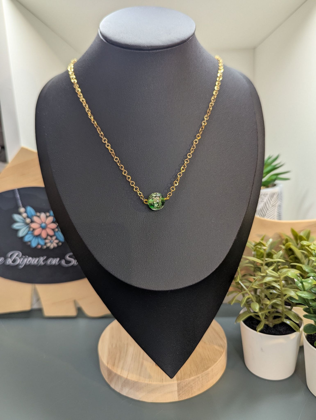 collier mi long avec chaine de couleur or et pendentif en verre de couleur vert foncé. 