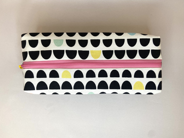 TROUSSE DE TOILETTE FUN AVEC SON ZIP ROSE ET SES MOTIFS GÉOMETRIQUES NOIRS ET PASTELS