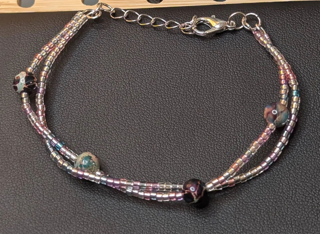 Bracelet torsadé rose, bleu, et violet avec des perles Miyuki en verre, des perles naturelles. Le fermoir est de couleur argenté.
