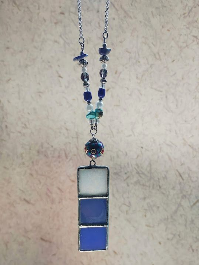 Pendentif en pâte de verre bleue et blanche, sertis en Tiffany et chaîne couleur argent. 